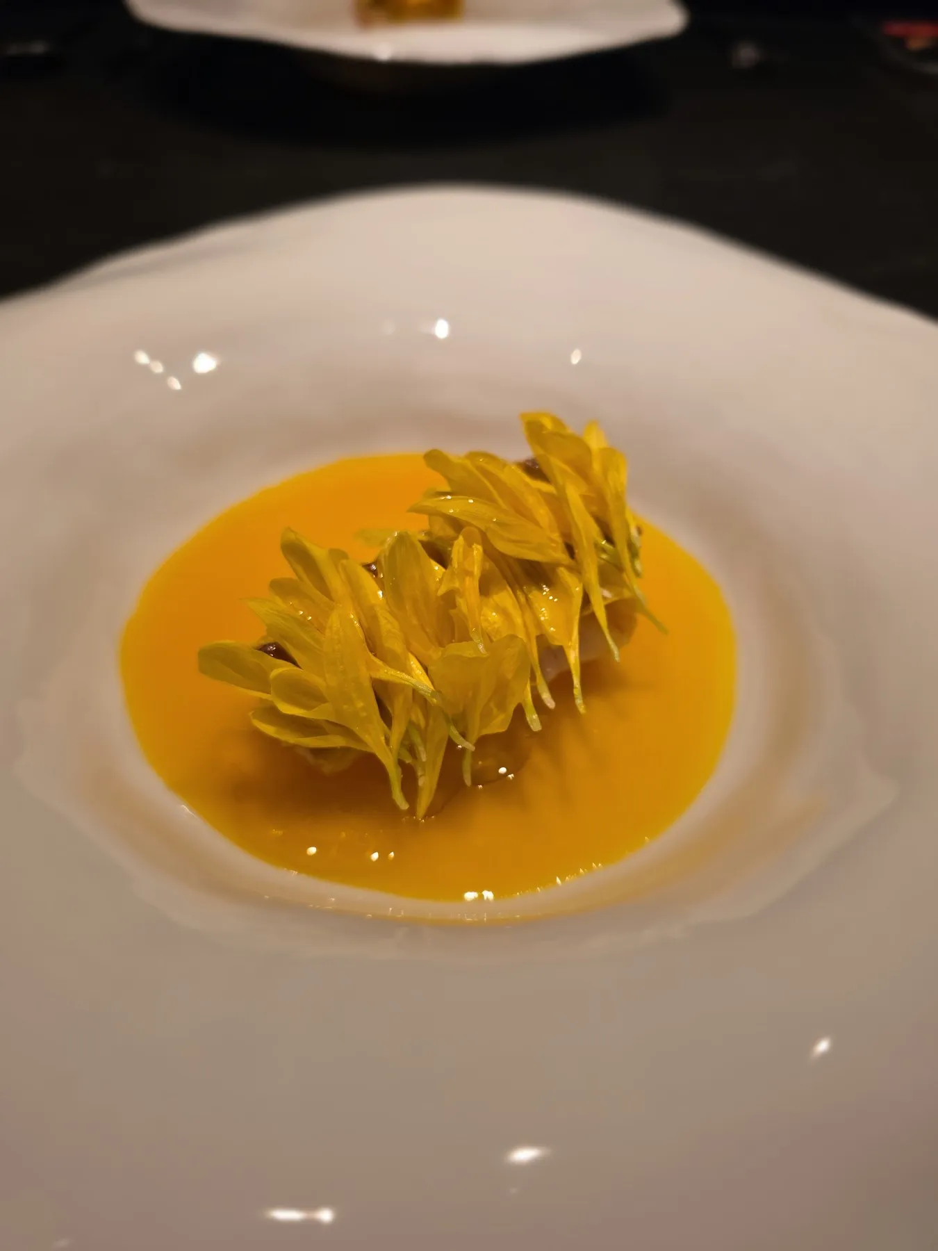 Bowl of yellow petals in golden broth