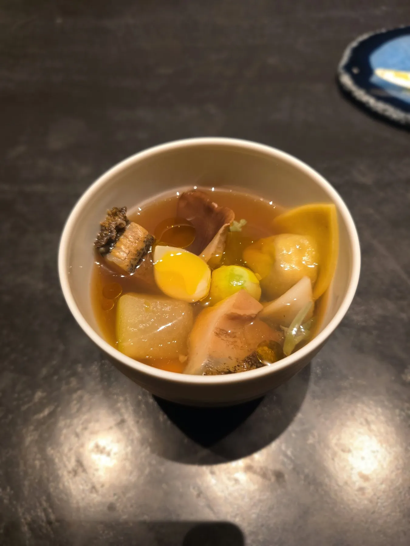 Bowl of clear broth with abalone, wax gourd, and ginkgo nuts