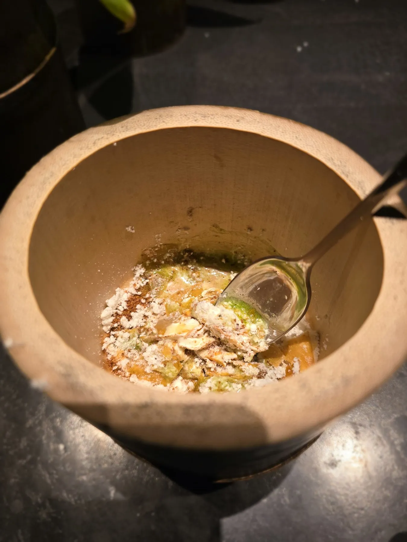 Stone mortar filled with shaved fresh cheese and oil