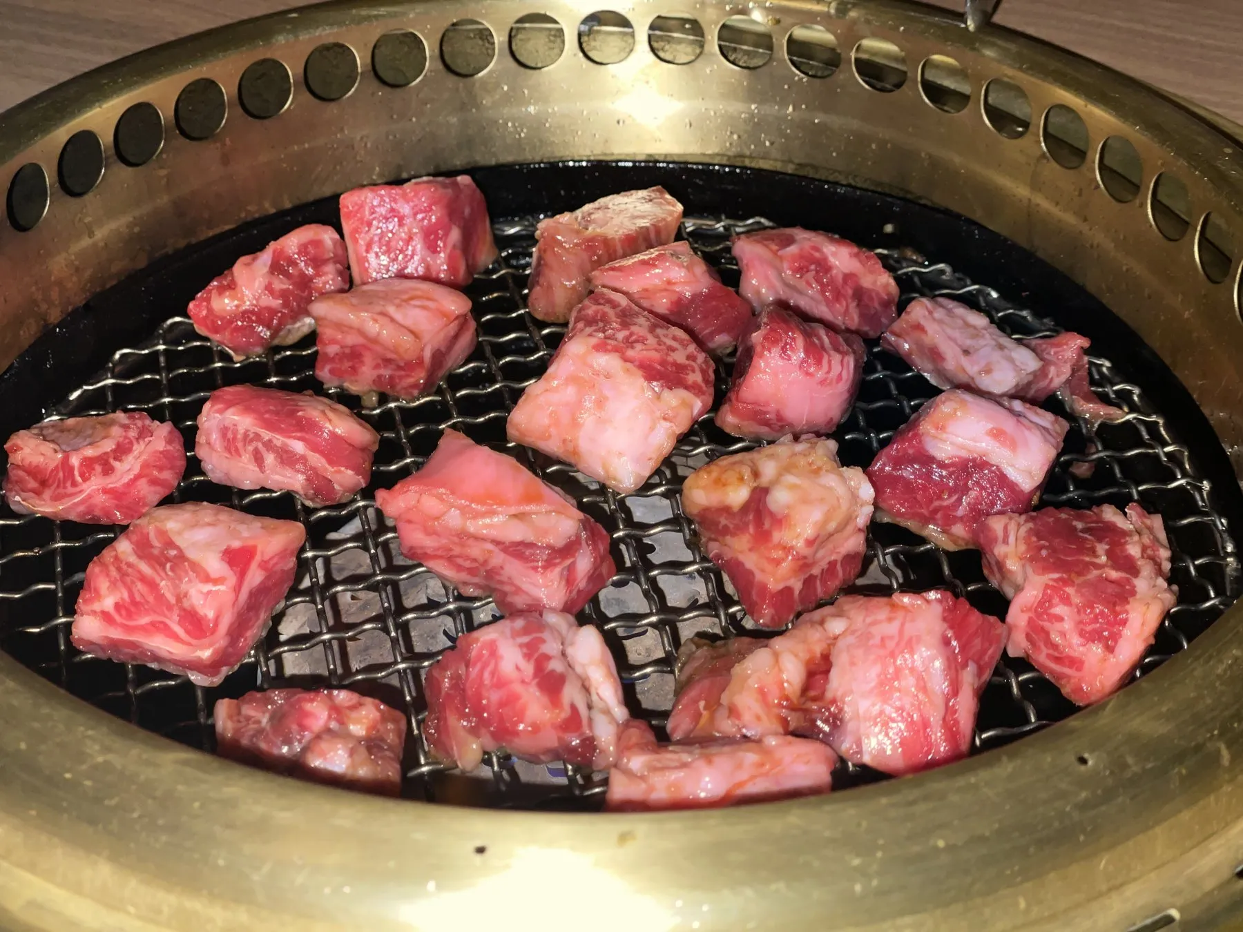 Cubes of marbled wagyu on a charcoal grill