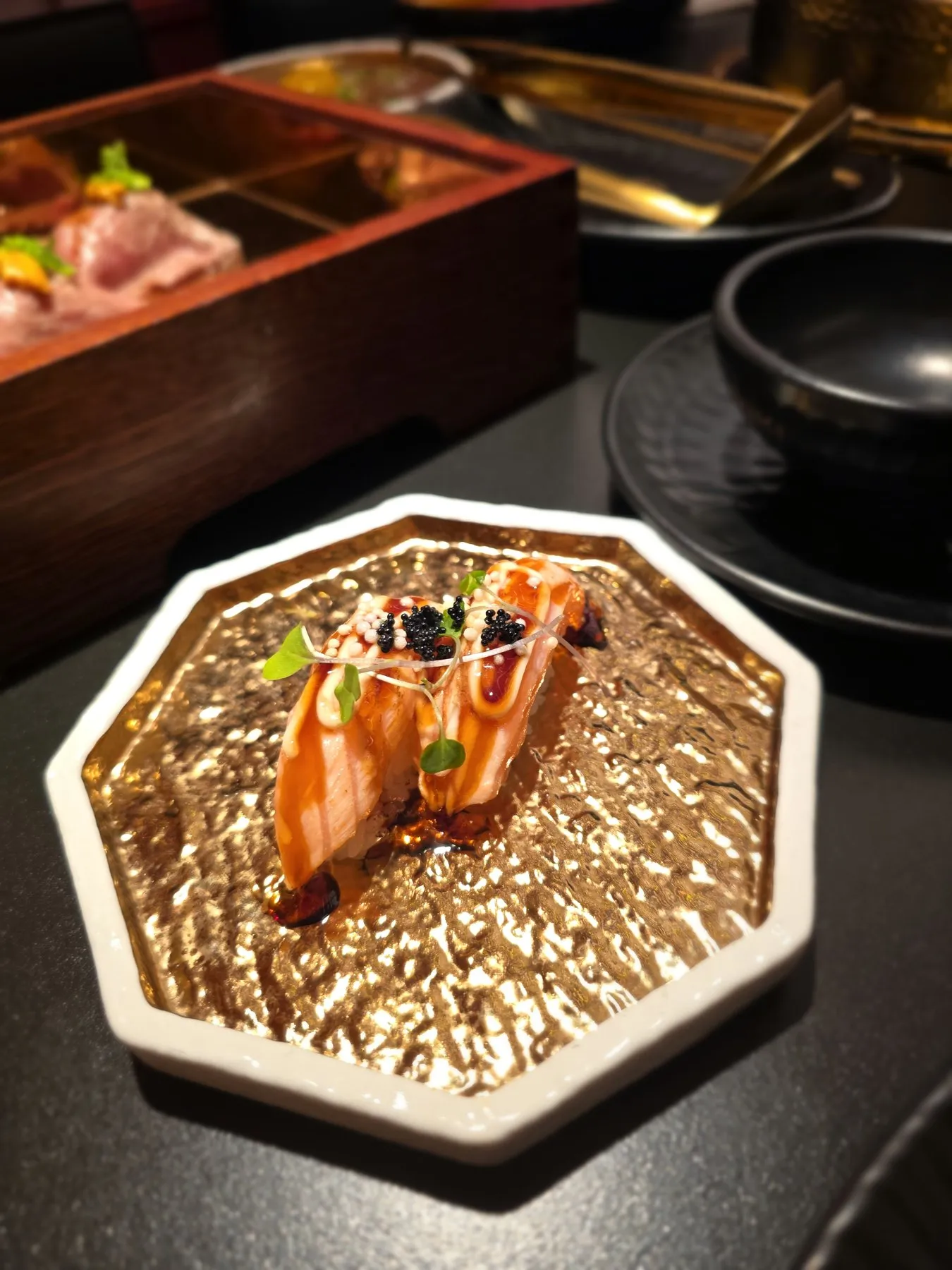 Aburi salmon nigiri on an octagonal gold plate