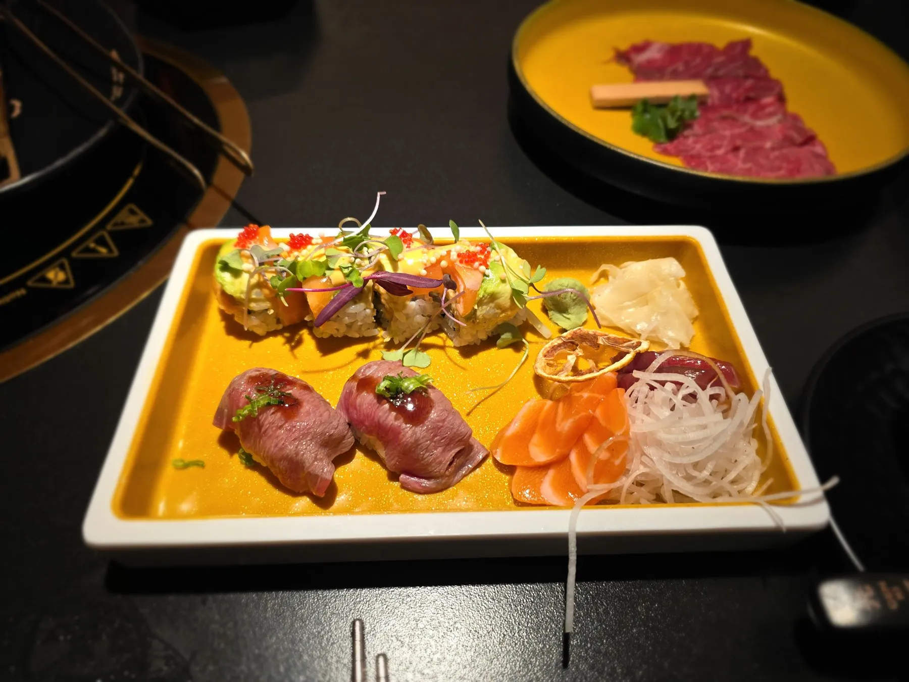 Platter of sashimi and nigiri on an orange tray