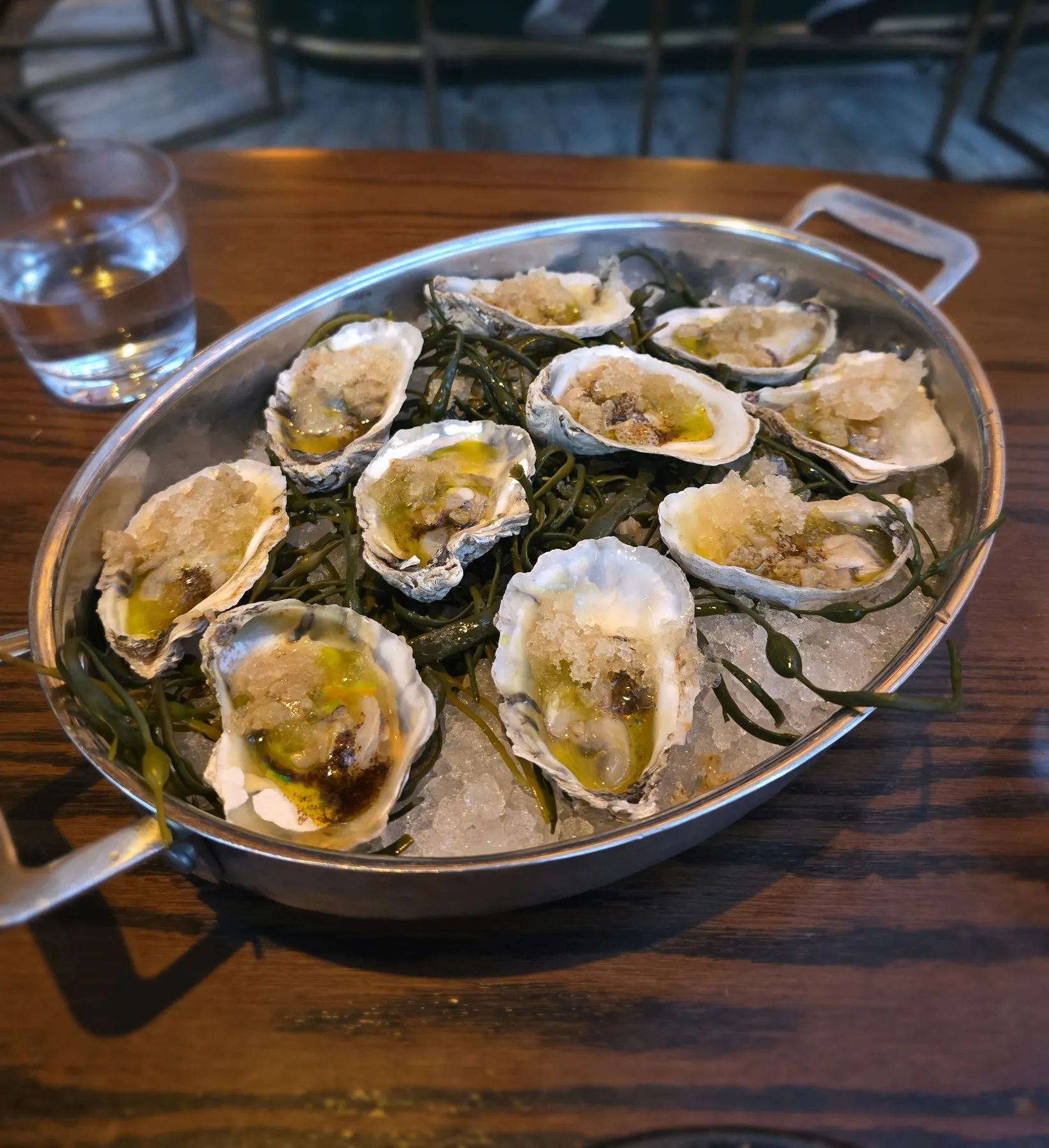Baked oysters in a pan with seaweed