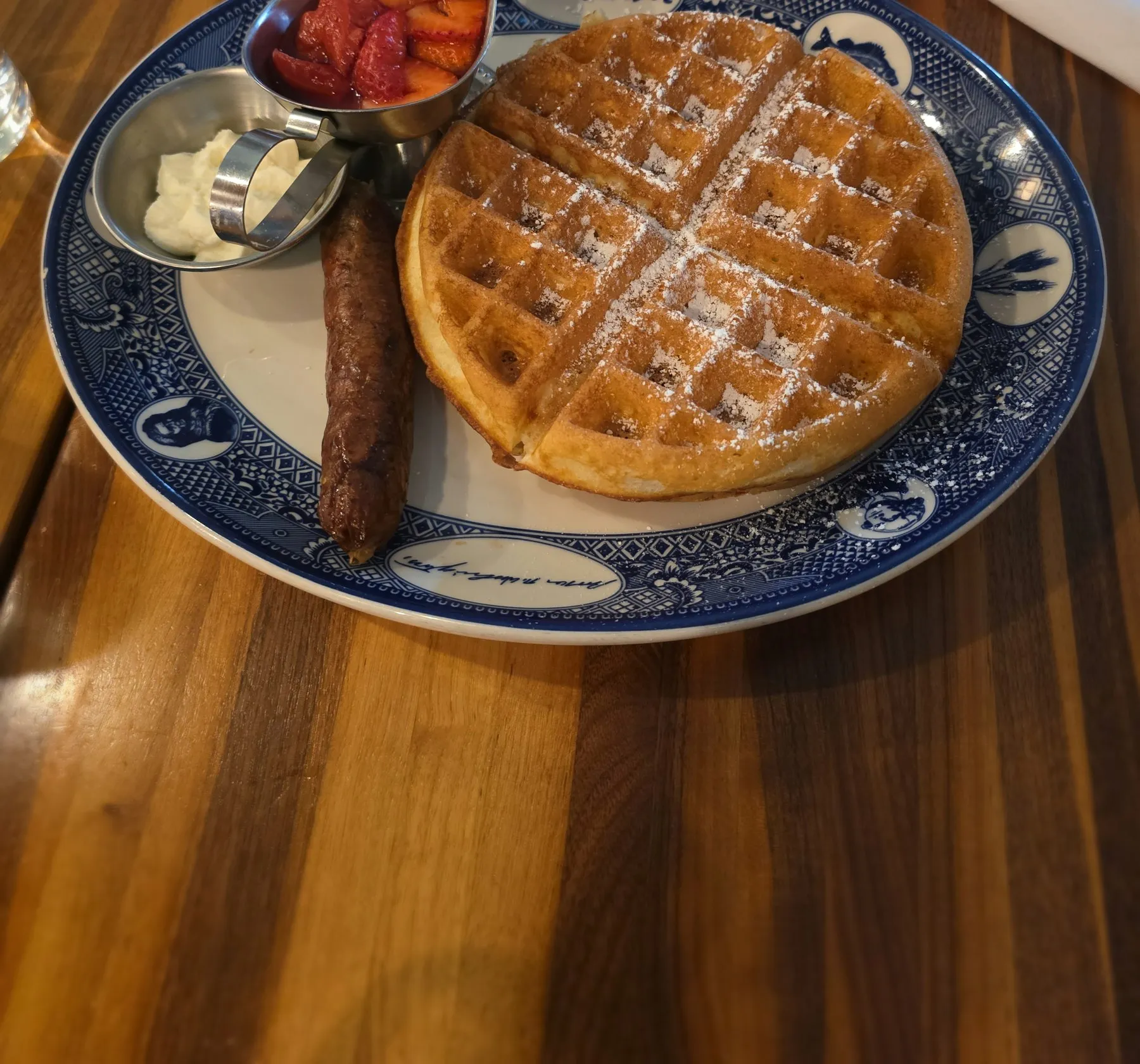 Waffle with bacon and strawberries on a blue plate
