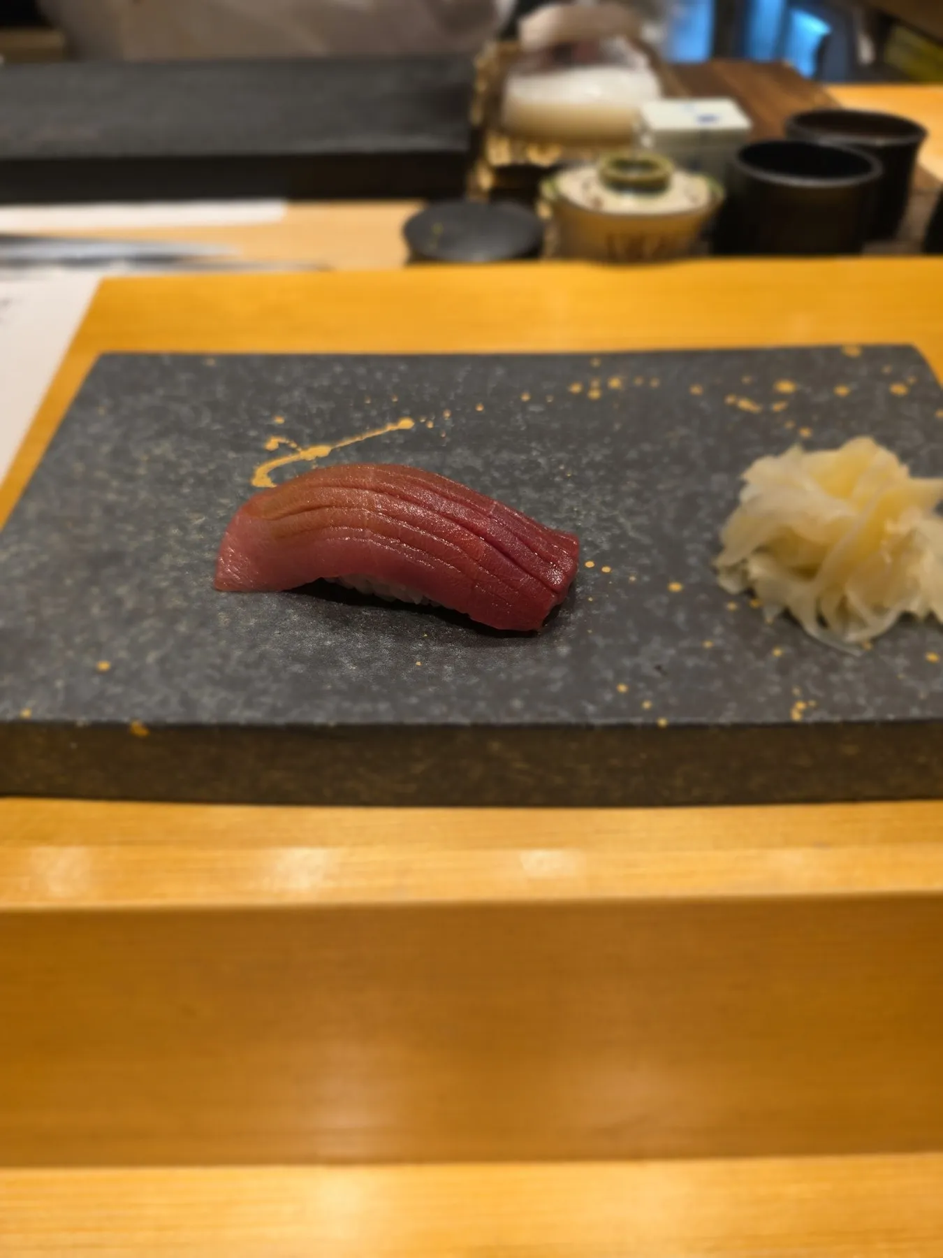 Tuna nigiri on a dark stone slab