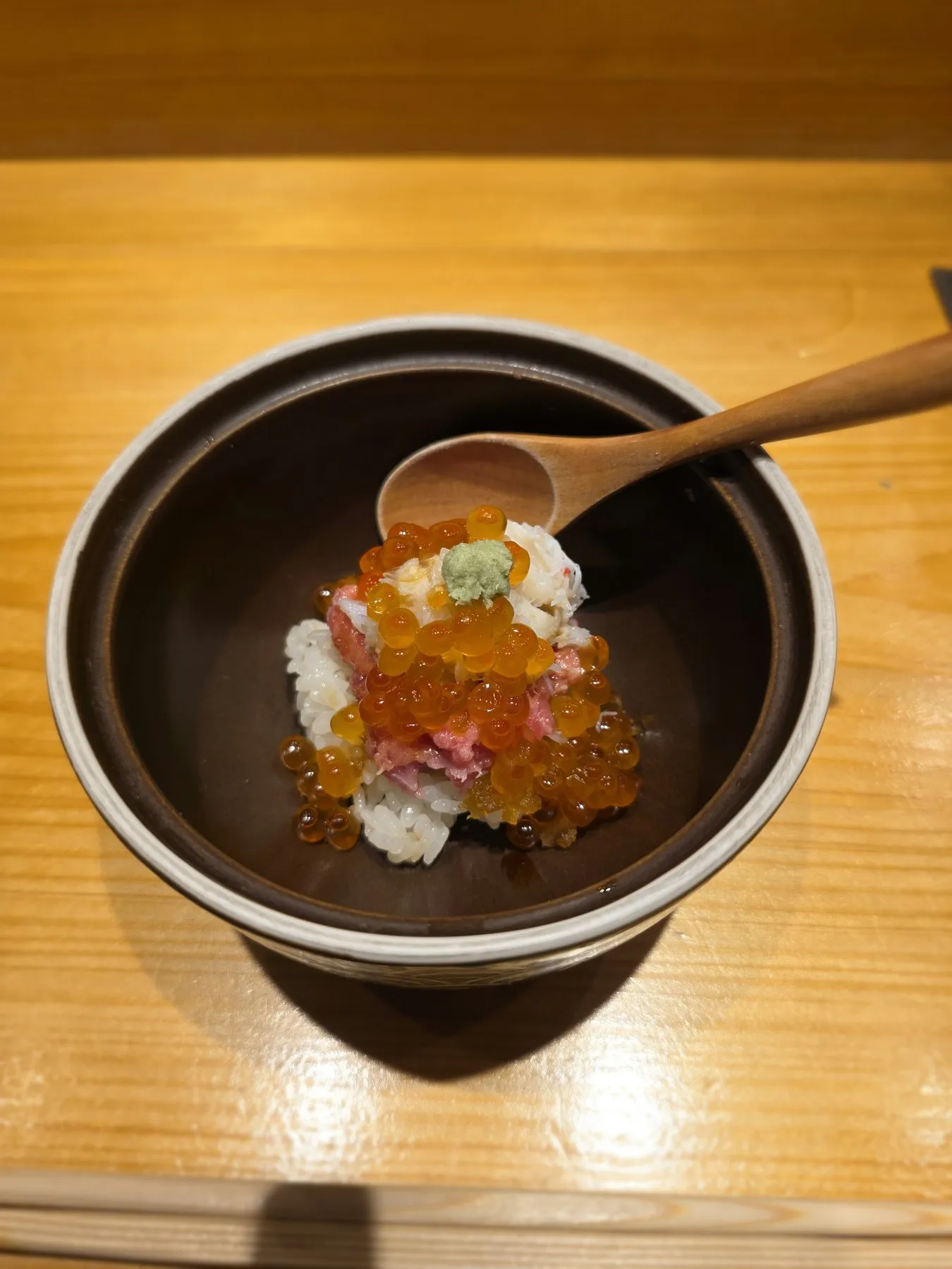 Clay pot of rice topped with ikura and uni