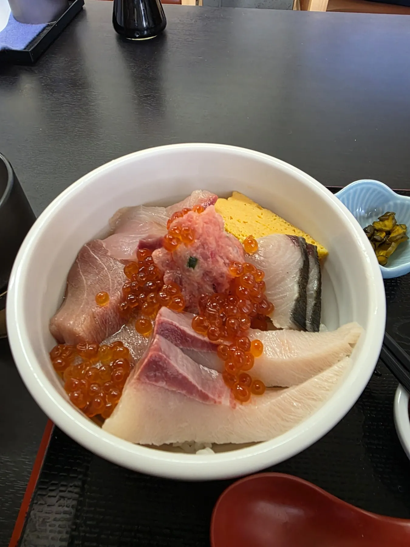 Bowl of rice topped with salmon roe, yellowtail, and tamago