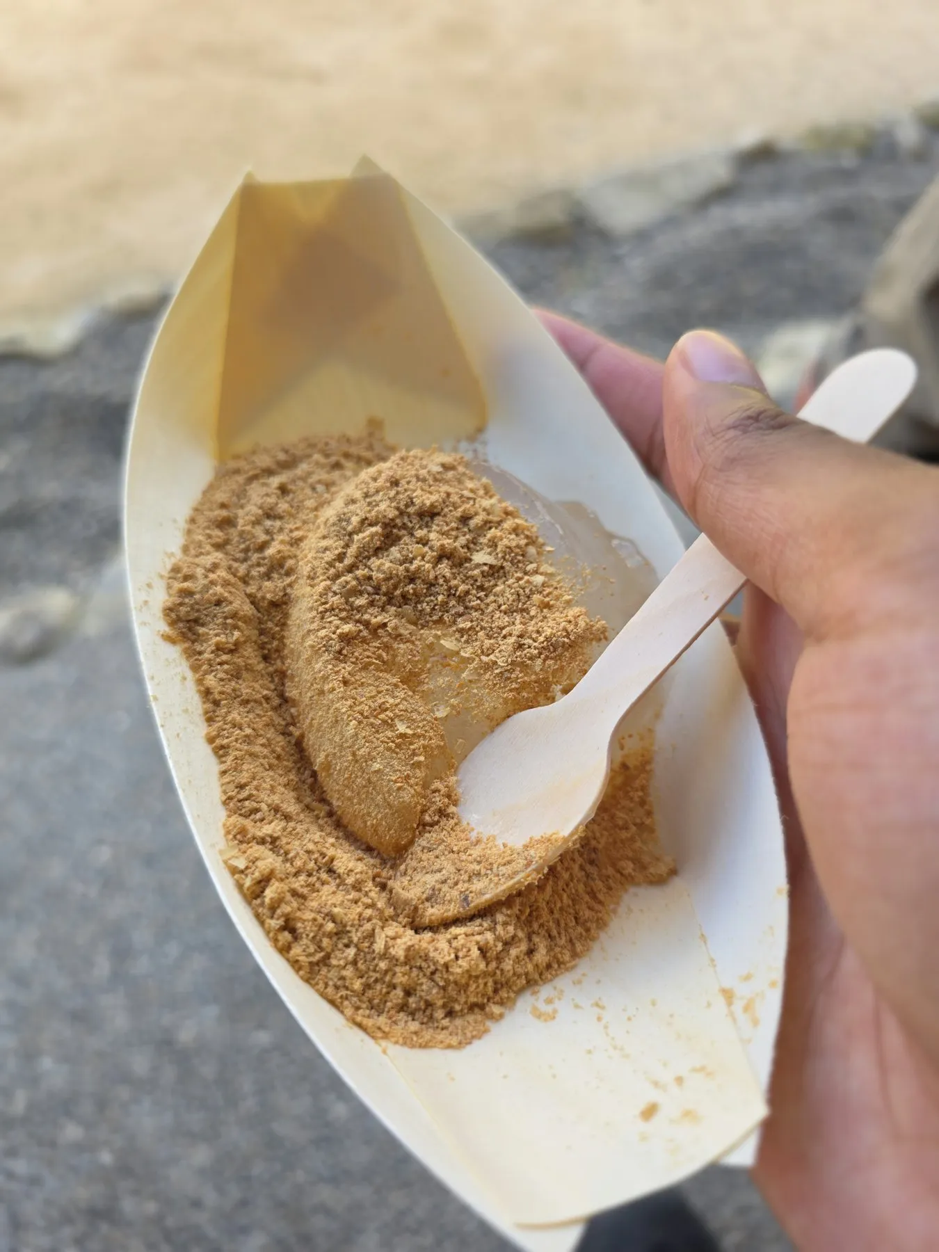 Warabi mochi in kinako held in a paper boat