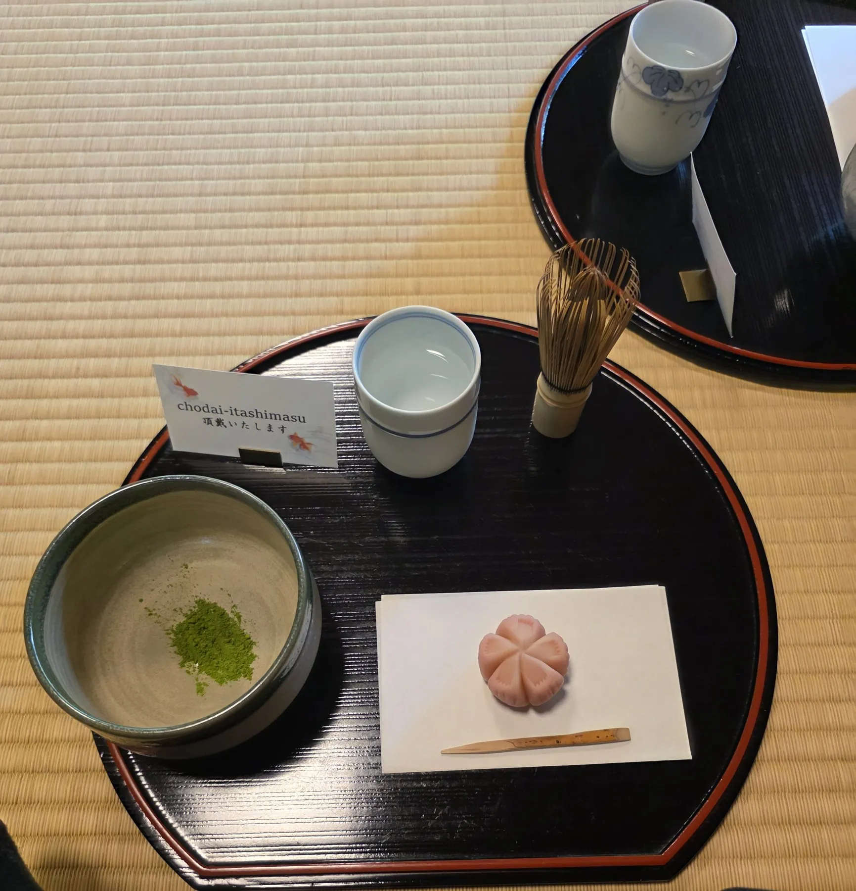 Wagashi, matcha bowl, and whisk on a lacquer tray
