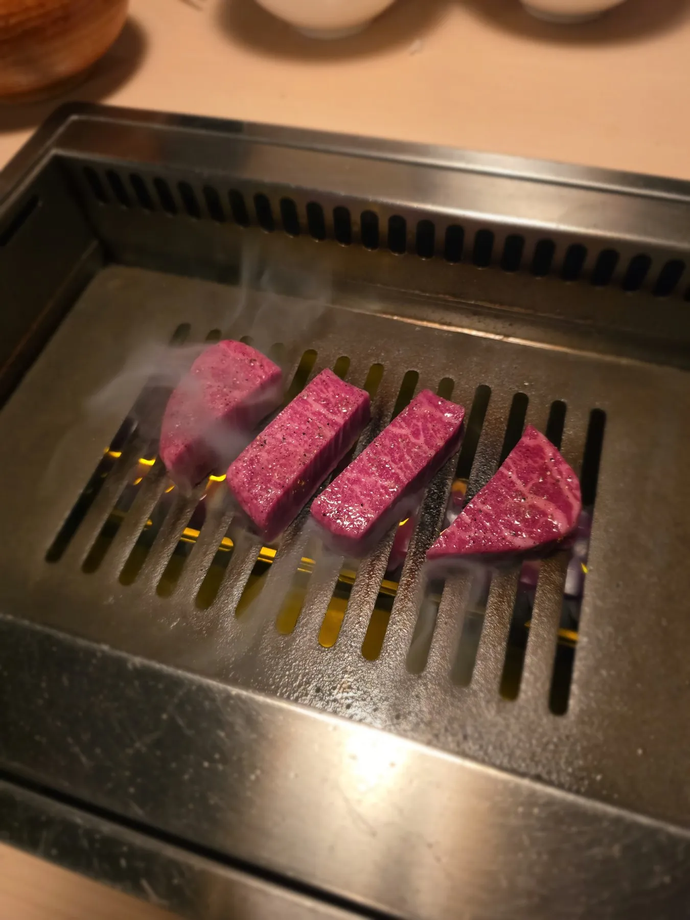 Slices of wagyu searing on a grill