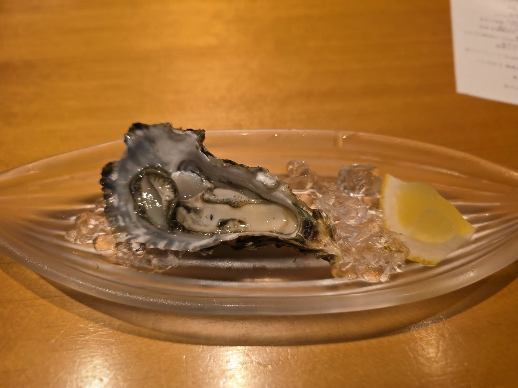 Single oyster on ice with lemon
