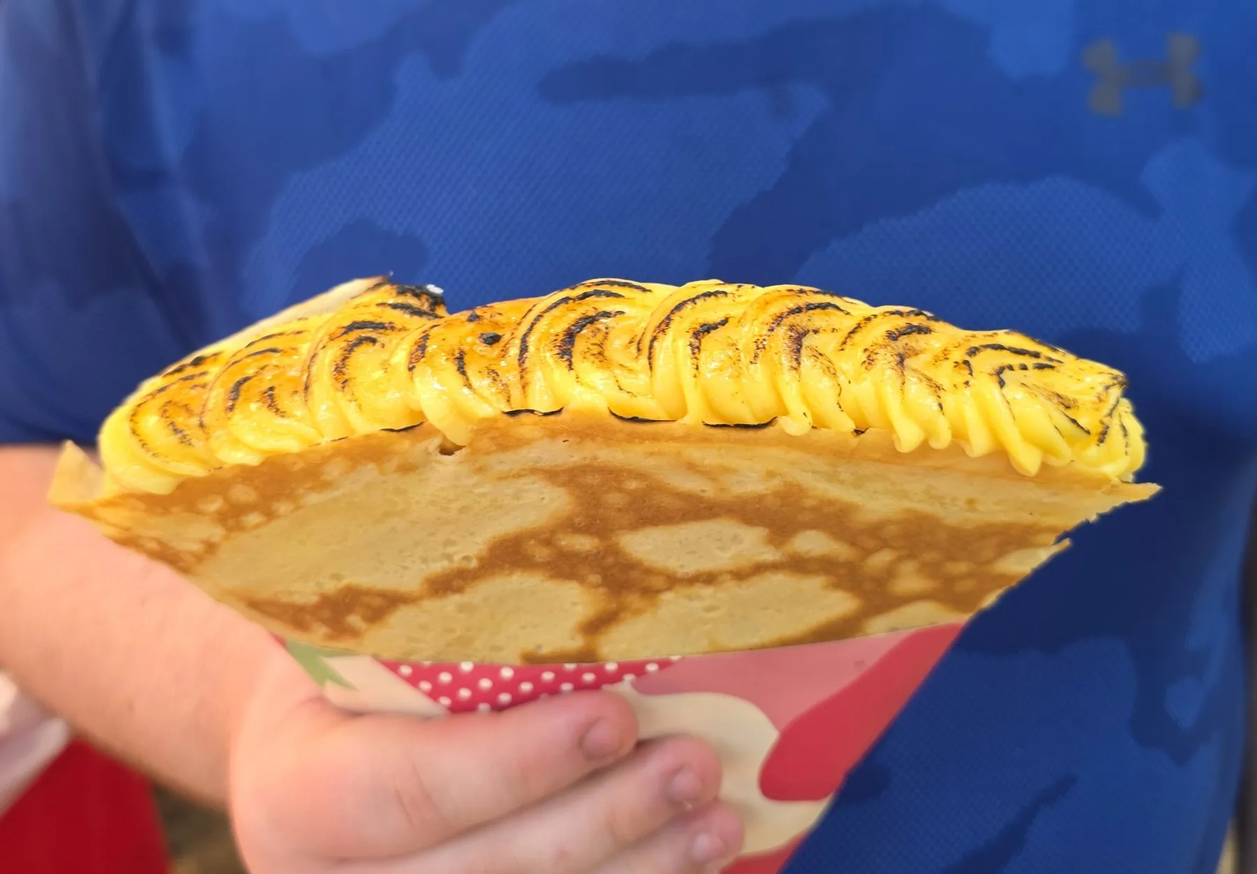 Crepe stuffed with sliced fruit, held up